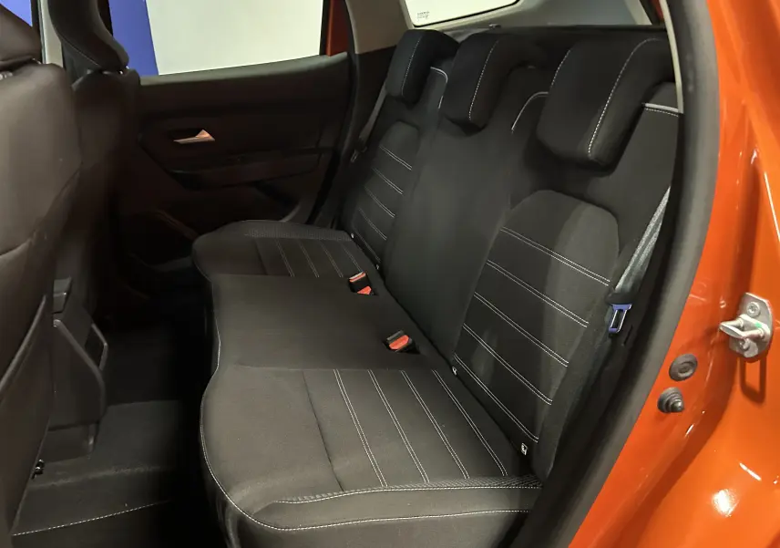 Vue côté droit de la banquette arrière noire avec surpiqûres blanches du Dacia Duster orange Arizona 2022.