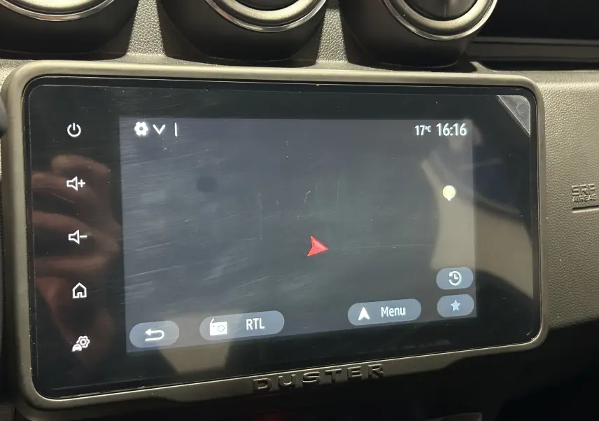 Écran tactile central du Dacia Duster 2022 affichant la navigation, entouré de commandes et aérateurs noirs.