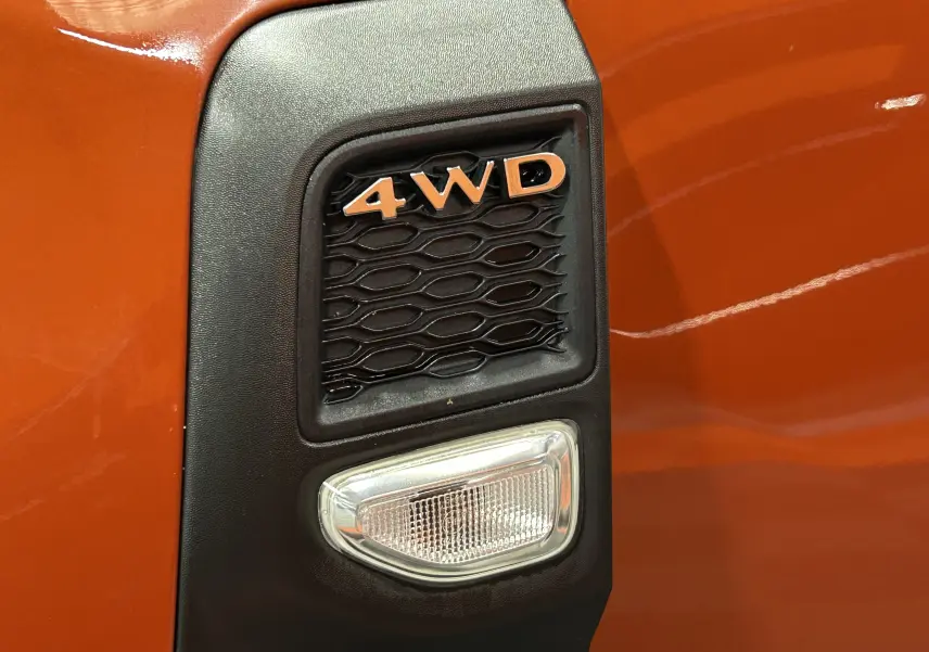 Détail de l'emblème 4WD sur la carrosserie orange Arizona du Dacia Duster DCI 115 Journey 4WD 2022.