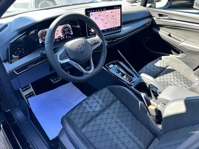 Intérieur noir de la Volkswagen Golf 1.5 eTSI R-Line 2025, vue côté conducteur sur le tableau de bord digital et la console centrale.