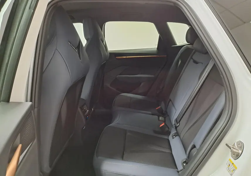 Vue intérieure arrière côté droit du CUPRA TERRAMAR blanc Nevada, montrant les sièges arrière en tissu et cuir noir.