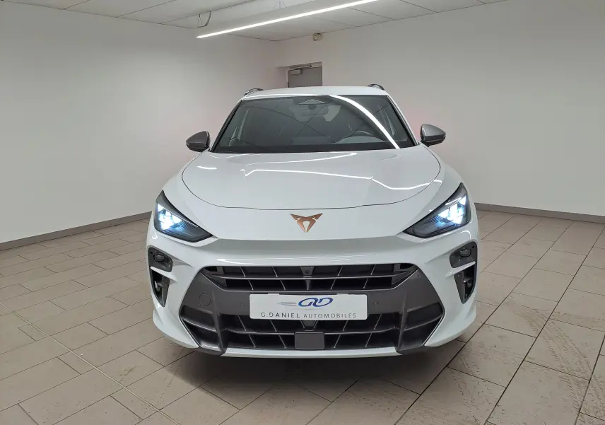 Vue frontale du CUPRA TERRAMAR blanc Nevada avec phares allumés et calandre noire distinctive.