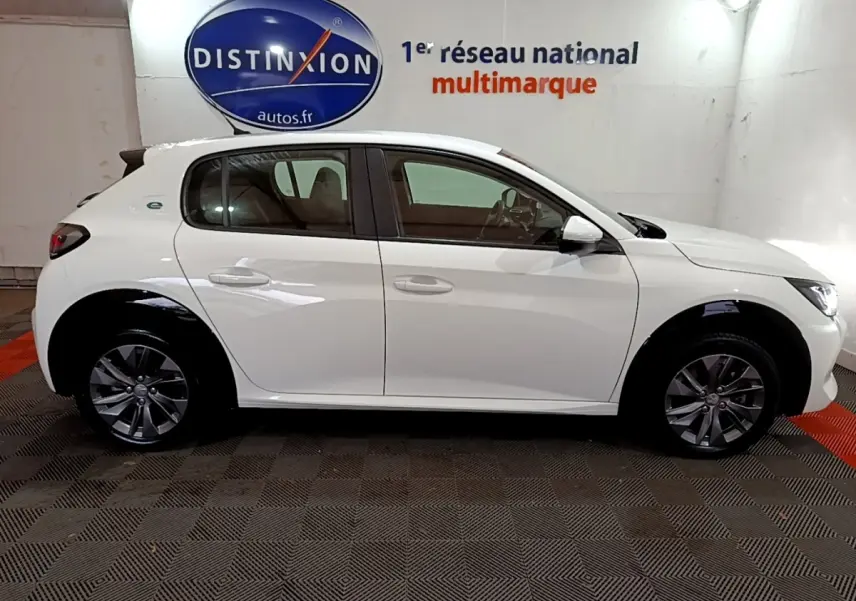 Peugeot 208 électrique blanche vue de profil côté gauche, avec jantes alliage et logo "e" arrière.