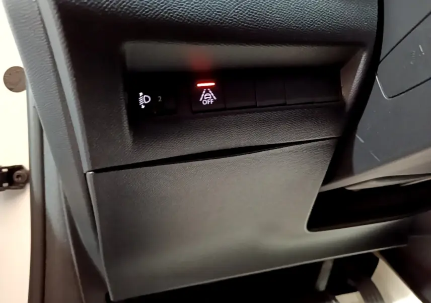 Détail intérieur du tableau de bord côté conducteur de la Peugeot 208 électrique Active Business 2021, bouton d'alerte franchissement de ligne activé.