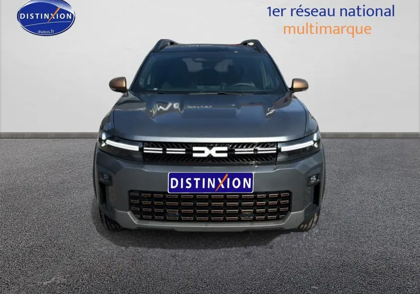 Vue frontale du Dacia Bigster gris schiste avec calandre distinctive et phares LED allumés.
