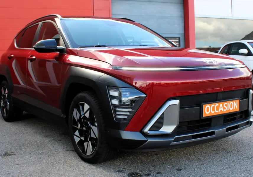 Hyundai Kona 2024 rouge Ultimate Metal vue 3/4 avant gauche avec détails noirs et jantes bicolores.