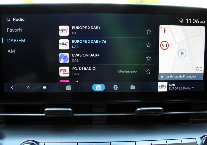Écran tactile central du Hyundai Kona 2024 affichant la radio DAB/FM et la navigation GPS en intérieur noir.