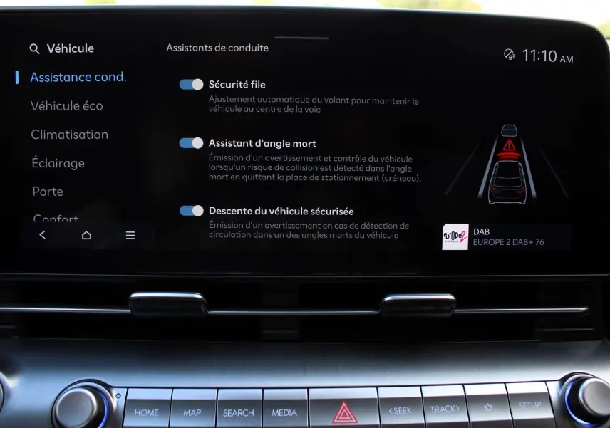 Affichage de l'écran tactile central de la Hyundai Kona 2024 montrant les options d'assistance à la conduite en intérieur noir.