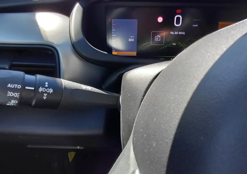 Vue rapprochée du combiné d'instruments numérique et du commodo gauche du Jeep Avenger blanc 2025, version Summit.
