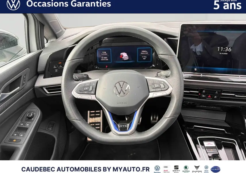 Vue rapprochée du volant sport multifonction en cuir avec logo VW et tableau de bord digital d'une Volkswagen Golf blanche.