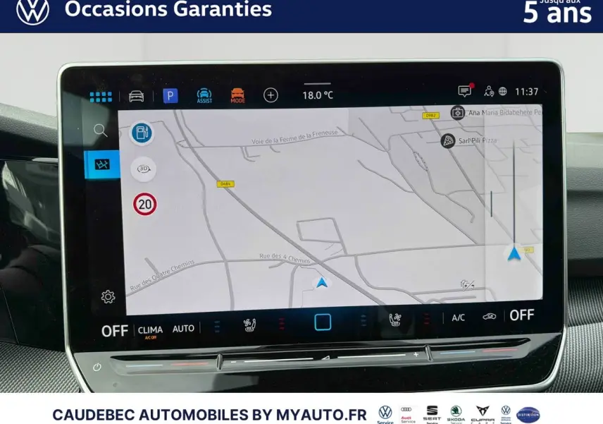 Écran tactile central affichant la navigation GPS dans l'habitacle d'une Volkswagen Golf blanche, vue intérieure.