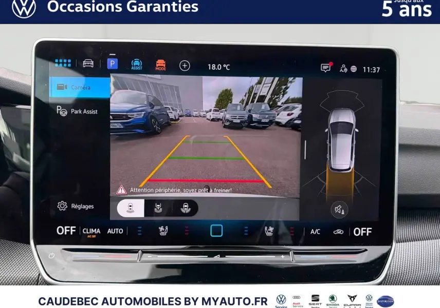 Écran tactile intérieur affichant la caméra de recul et l’aide au stationnement d’une Volkswagen Golf blanche.