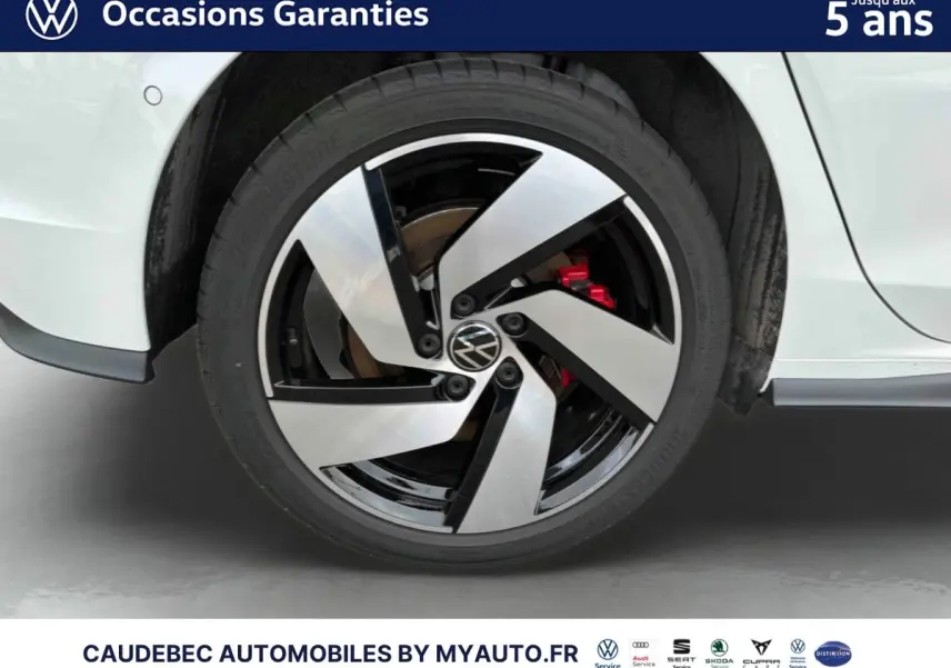 Gros plan sur la roue arrière droite d'une Volkswagen Golf 1.5 eHybrid blanche avec jante alliage Richmond noire et argent.