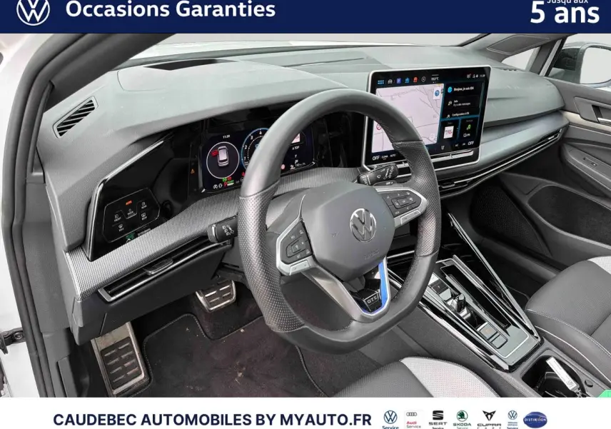 Vue intérieure côté conducteur de la Volkswagen Golf 1.5 eHybrid 2025, volant sport cuir et écran tactile central.