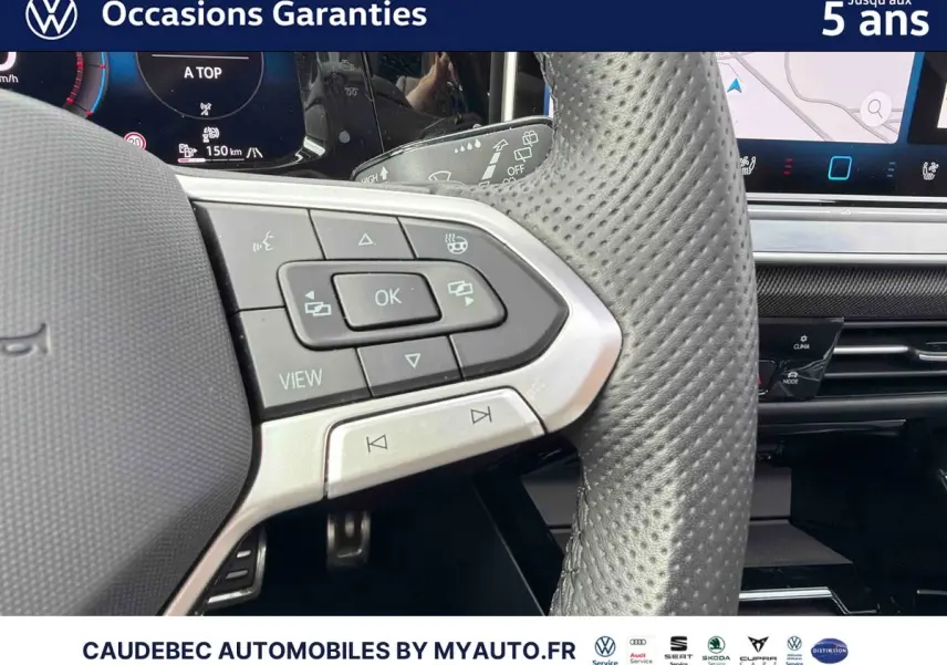 Gros plan sur le volant sport en cuir perforé et les commandes multifonctions de la Volkswagen Golf 1.5 eHybrid blanche de 2025.