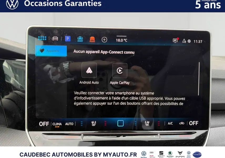 Vue intérieure centrée sur l'écran tactile du système multimédia d'une Volkswagen Golf blanche de 2025.
