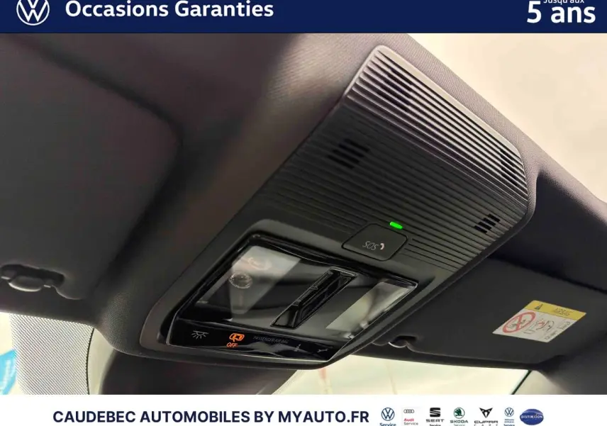 Vue intérieure en gros plan du plafonnier noir avec commandes d’éclairage et bouton SOS d’une Volkswagen Golf blanche 2025.