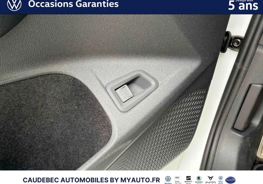 Détail de la porte côté conducteur d’une Volkswagen Golf 1.5 eHybrid blanche, montrant la commande d’ouverture du réservoir.