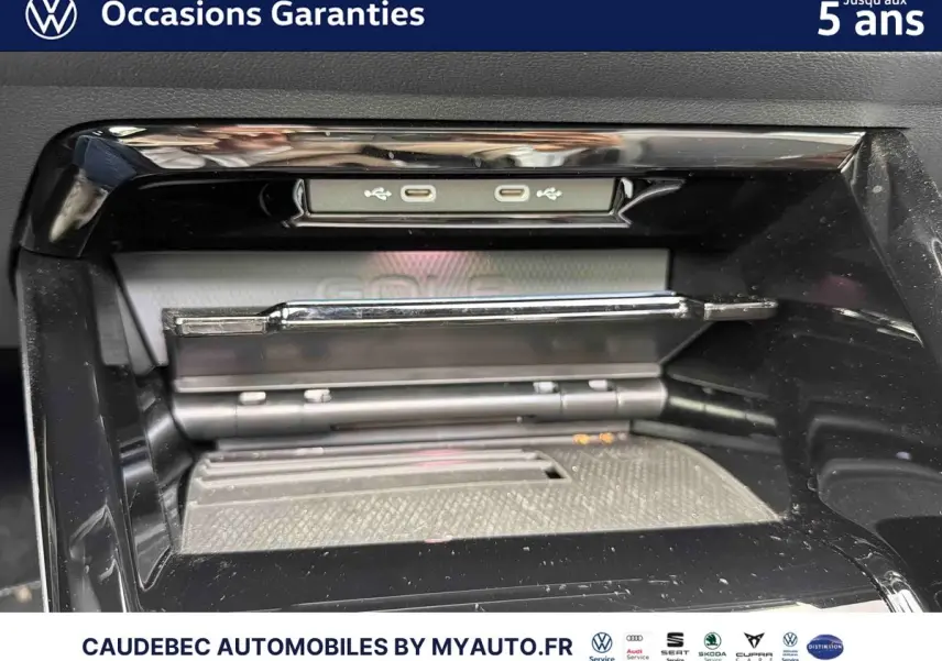 Détail de la console centrale noire de la Volkswagen Golf eHybrid 2025 avec ports USB-C et plateau de recharge.