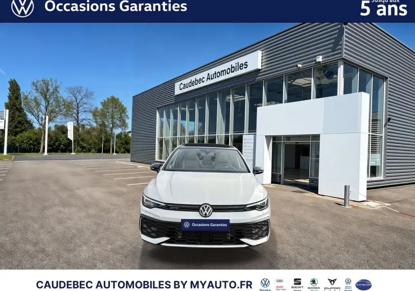 Volkswagen Golf 1.5 eHybrid 272 DSG6 blanche vue de face devant un showroom Caudebec Automobiles.