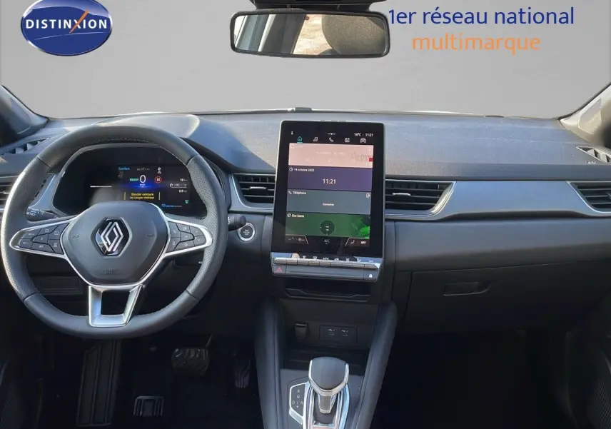 Vue intérieure frontale du tableau de bord du Renault Captur E-Tech blanc nacré avec écran tactile vertical et volant multifonctions.