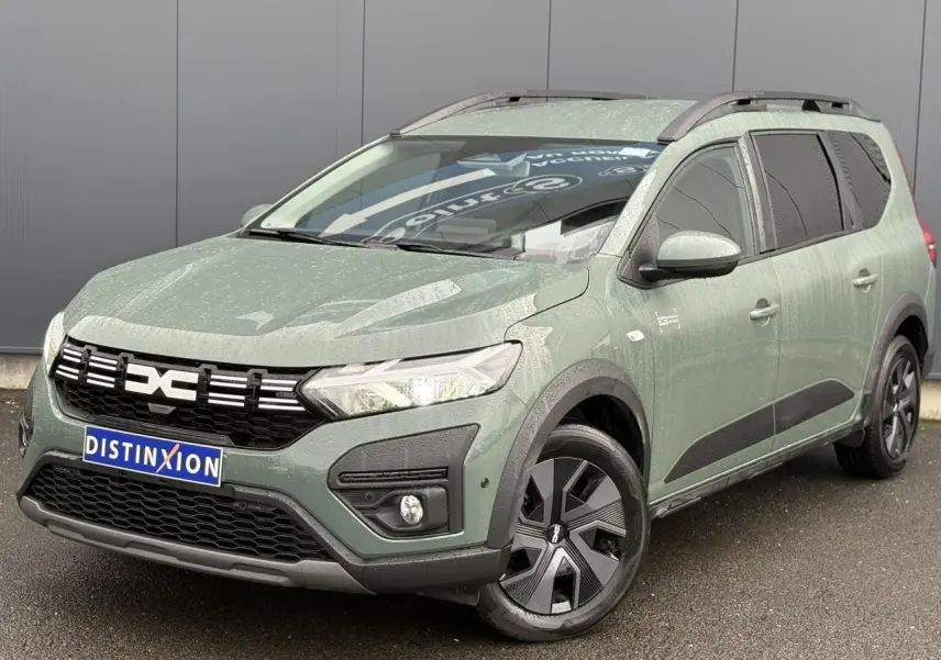 Dacia Jogger ECO-G 2025 kaki lichen en 3/4 avant droit avec barres de toit et jantes spécifiques.