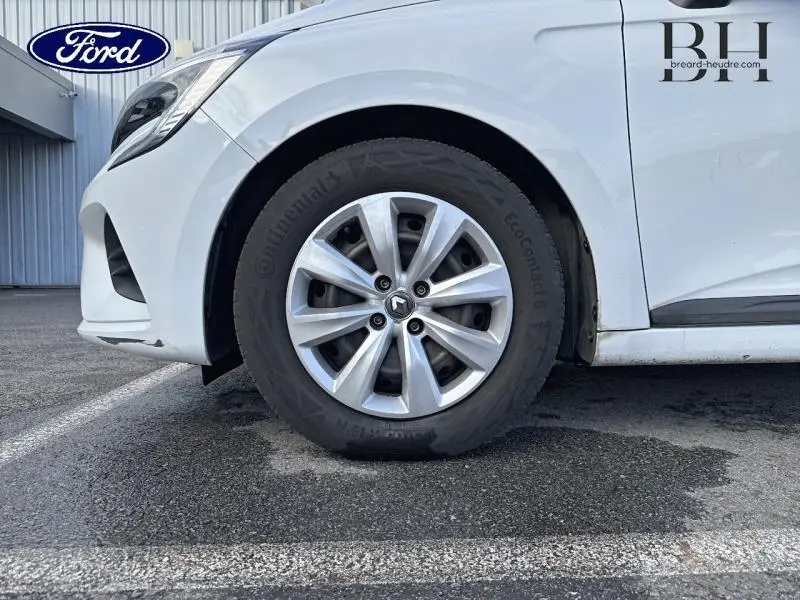 Gros plan sur la roue avant gauche blanche d'une Renault Clio 1.0 SCe 65ch Life 2020 avec jante en alliage et logo Renault.