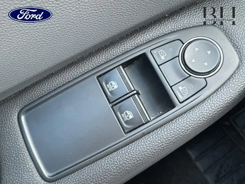 Gros plan sur les commandes de lève-vitres et réglage des rétroviseurs côté conducteur, finition noire.