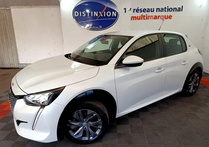 Peugeot 208 électrique blanche vue en 3/4 avant droit, avec phares LED et jantes alliage gris.