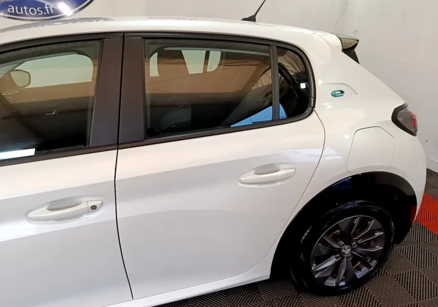 Vue latérale droite d'une Peugeot 208 électrique blanche, avec badge "e" distinctif sur l'aile arrière.