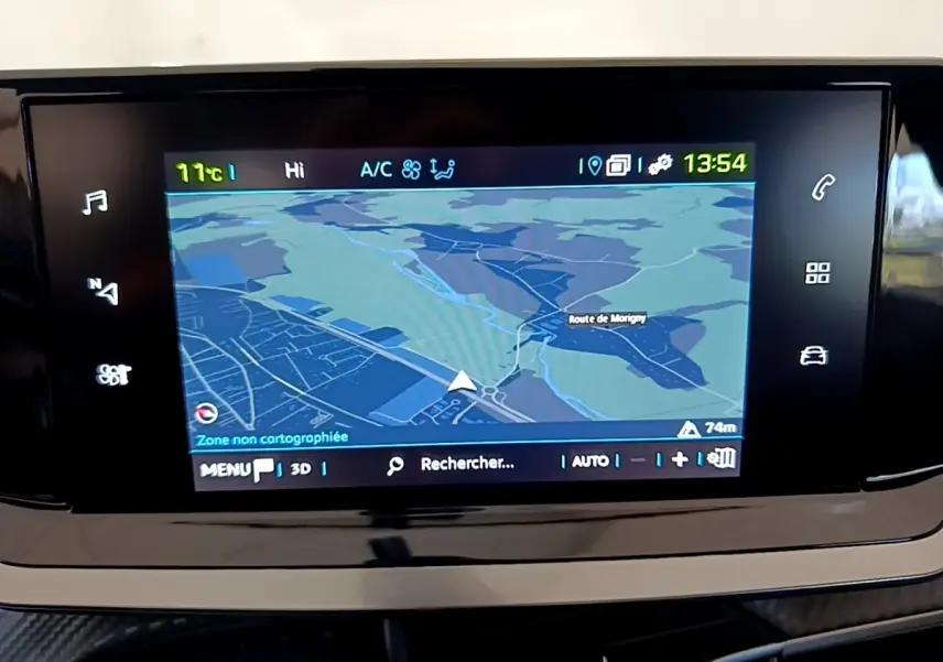 Écran tactile central affichant la navigation GPS dans l’habitacle d’une Peugeot 208 électrique blanche, vue de face.