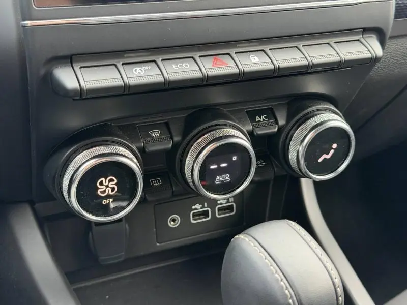 Gros plan sur les commandes de climatisation et boutons de fonction du tableau de bord du Renault Arkana blanc 2025.