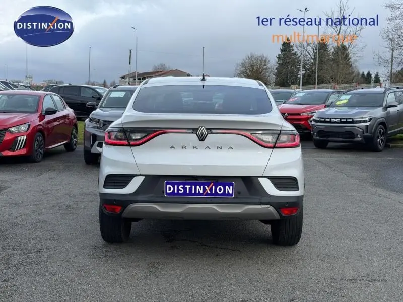 Vue arrière d'un Renault Arkana blanc 2025 avec feux reliés par un bandeau lumineux rouge.