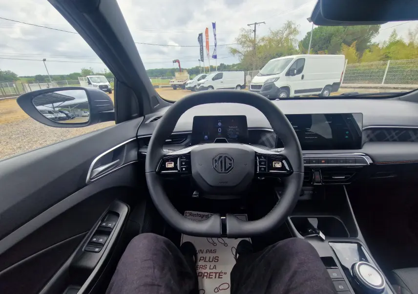 Vue intérieure centrée sur le volant du MG3 1.5L Hybrid+ 195ch Luxury, tableau de bord moderne et écran tactile visible.