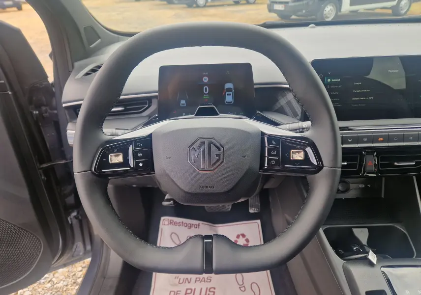 Vue centrée sur le volant noir du MG3 2026 avec tableau de bord numérique et écran tactile en arrière-plan.