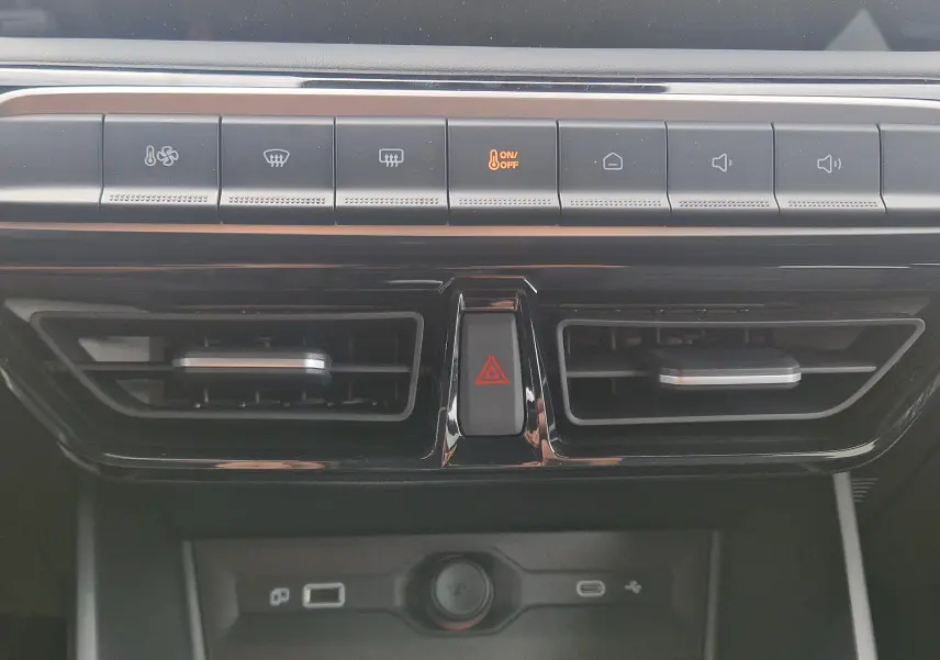 Vue rapprochée de la console centrale du MG3 2026, boutons de climatisation et aérateurs noirs brillants.