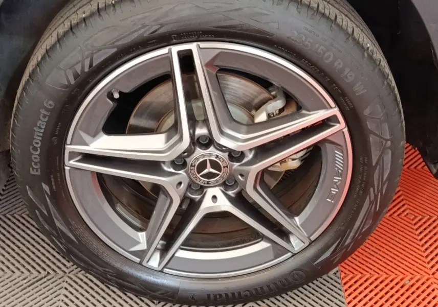 Gros plan sur la jante AMG grise et pneu Continental EcoContact 6 d’un Mercedes GLA 250 e noir.