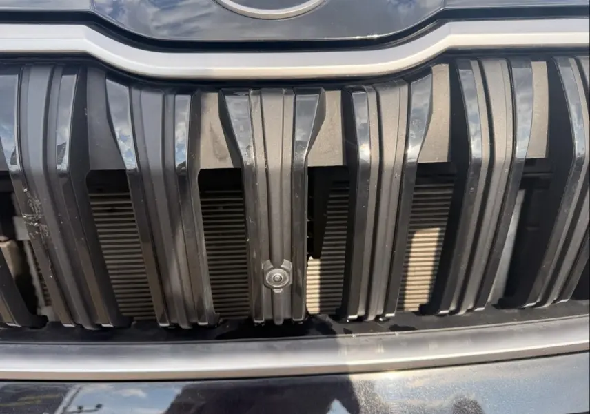Gros plan sur la calandre noire verticale du Skoda Kodiaq 2024 avec capteur de stationnement intégré.