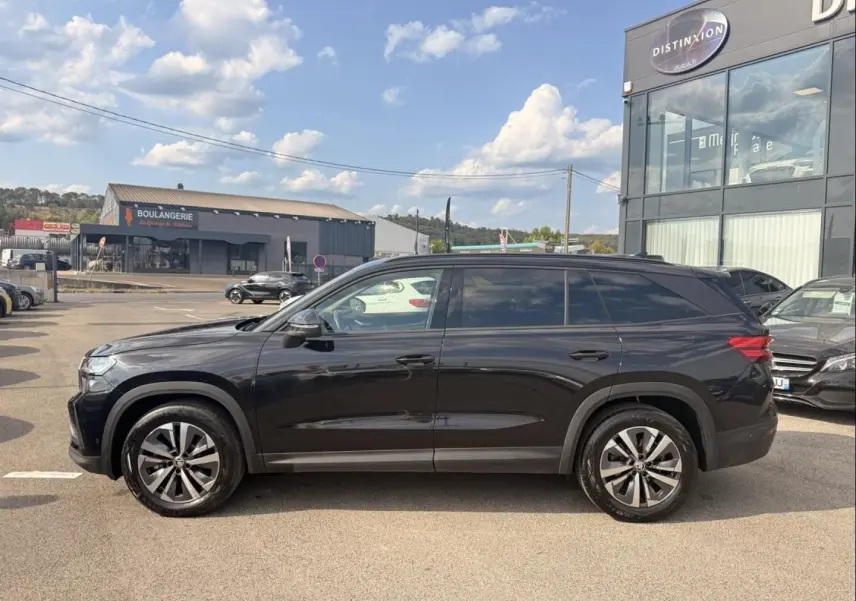 Vue de profil côté gauche d’un Skoda Kodiaq noir 2024, SUV 7 places avec jantes alliage distinctives.