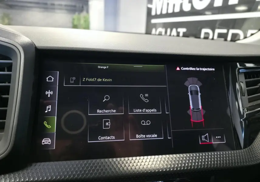Affichage central tactile de l'Audi A1 Sportback 2024 montrant l'interface téléphone et l'aide au stationnement.