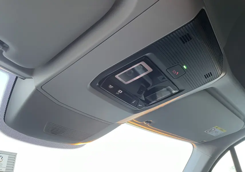 Vue intérieure du plafonnier gris clair du Volkswagen Crafter Van 2025 avec commandes d'éclairage et bouton SOS allumé.