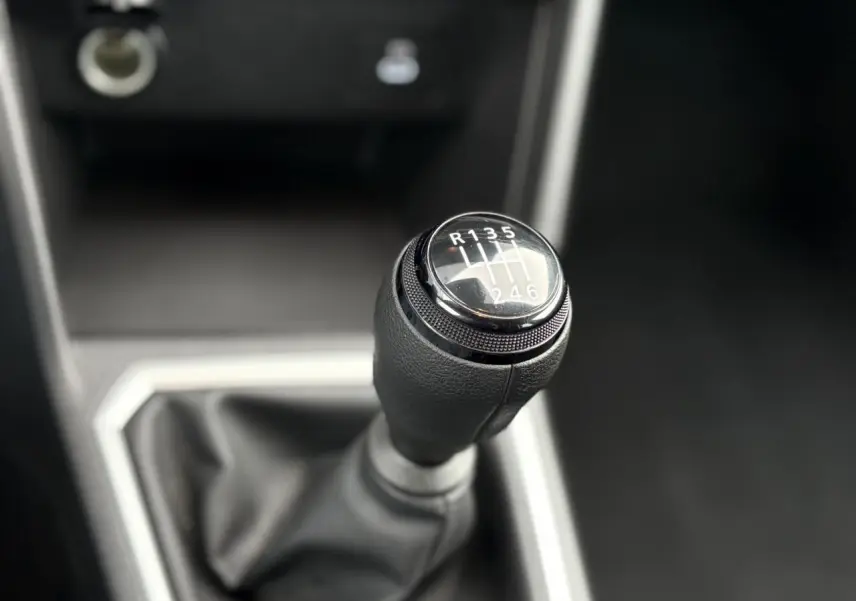 Le levier de vitesses manuel en gros plan dans l'habitacle sombre du Dacia Jogger Kaki Lichen 2025.