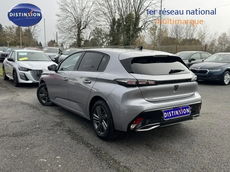 Vue 3/4 arrière droite d'une Peugeot 308 2024 gris Artense avec feux arrière LED et jantes alliage sombres.