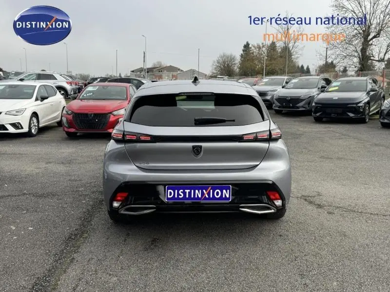 Vue arrière d'une Peugeot 308 2024 gris Artense avec feux LED distinctifs et double sortie d'échappement intégrée.