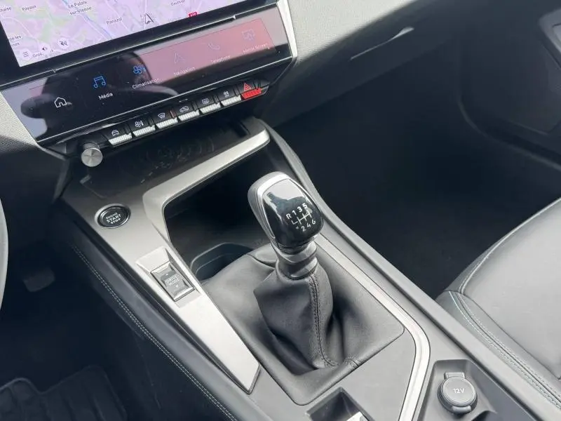Vue rapprochée de la console centrale de la Peugeot 308 2024 avec levier de vitesse manuel et écran tactile gris Artense.