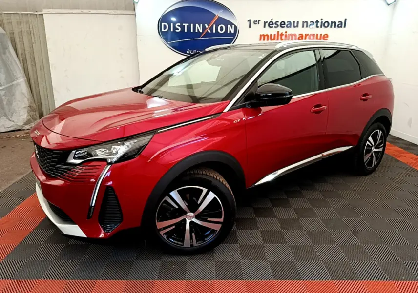 Peugeot 3008 GT rouge vue en 3/4 avant droit, avec jantes alliage et toit noir contrasté dans un showroom.