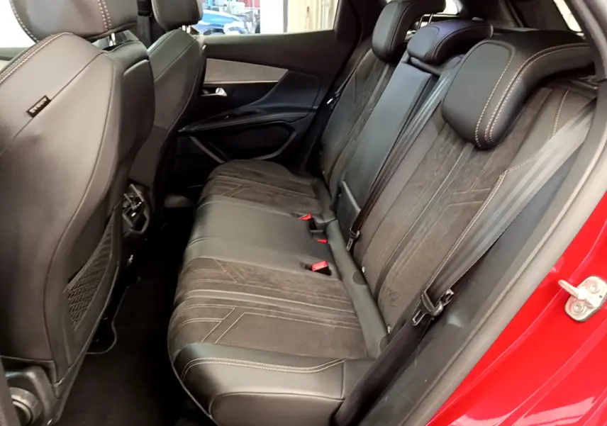 Vue côté droit sur les sièges arrière en cuir et alcantara du Peugeot 3008 GT rouge, avec détails de couture apparents.