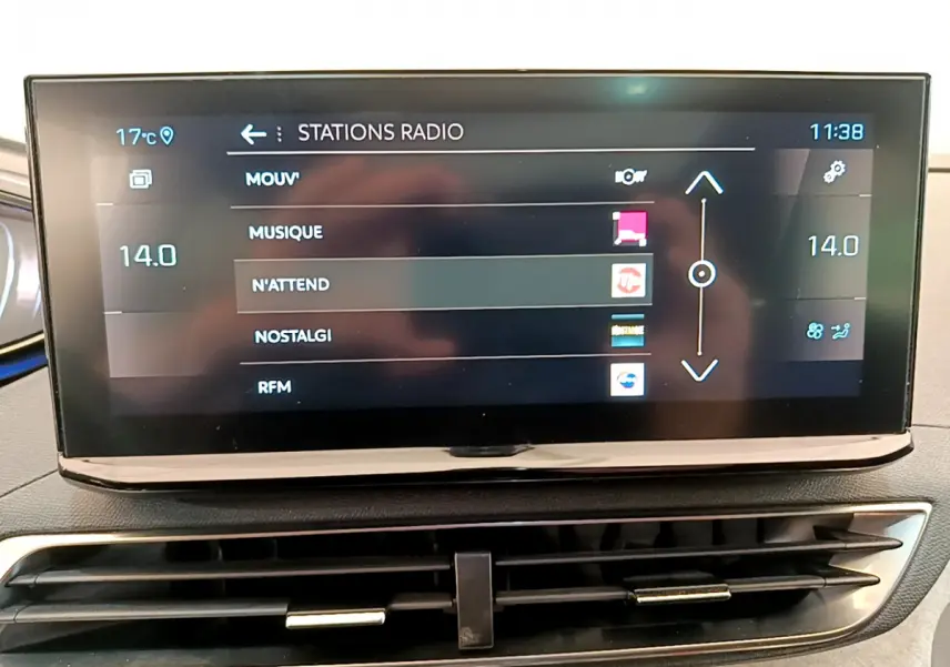 Écran tactile central affichant les stations radio dans l'habitacle d'une Peugeot 3008 GT rouge, vue de face.