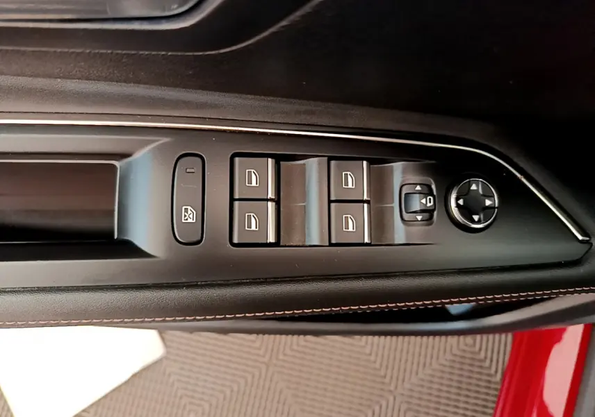 Gros plan sur les commandes des vitres et rétroviseurs côté conducteur du PEUGEOT 3008 rouge, intérieur noir.