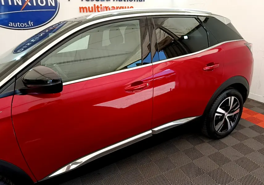 Vue côté droit d’un Peugeot 3008 GT rouge de 2021, avec jantes alliage et détails chromés sur les bas de caisse.